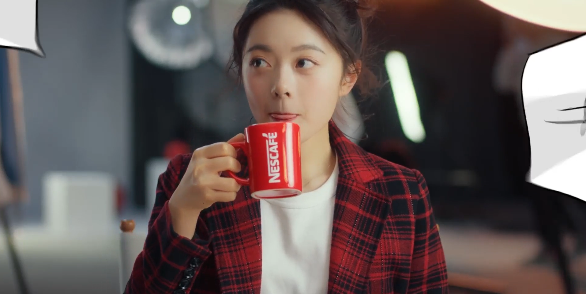 Young woman drinking Nescafé from red mug